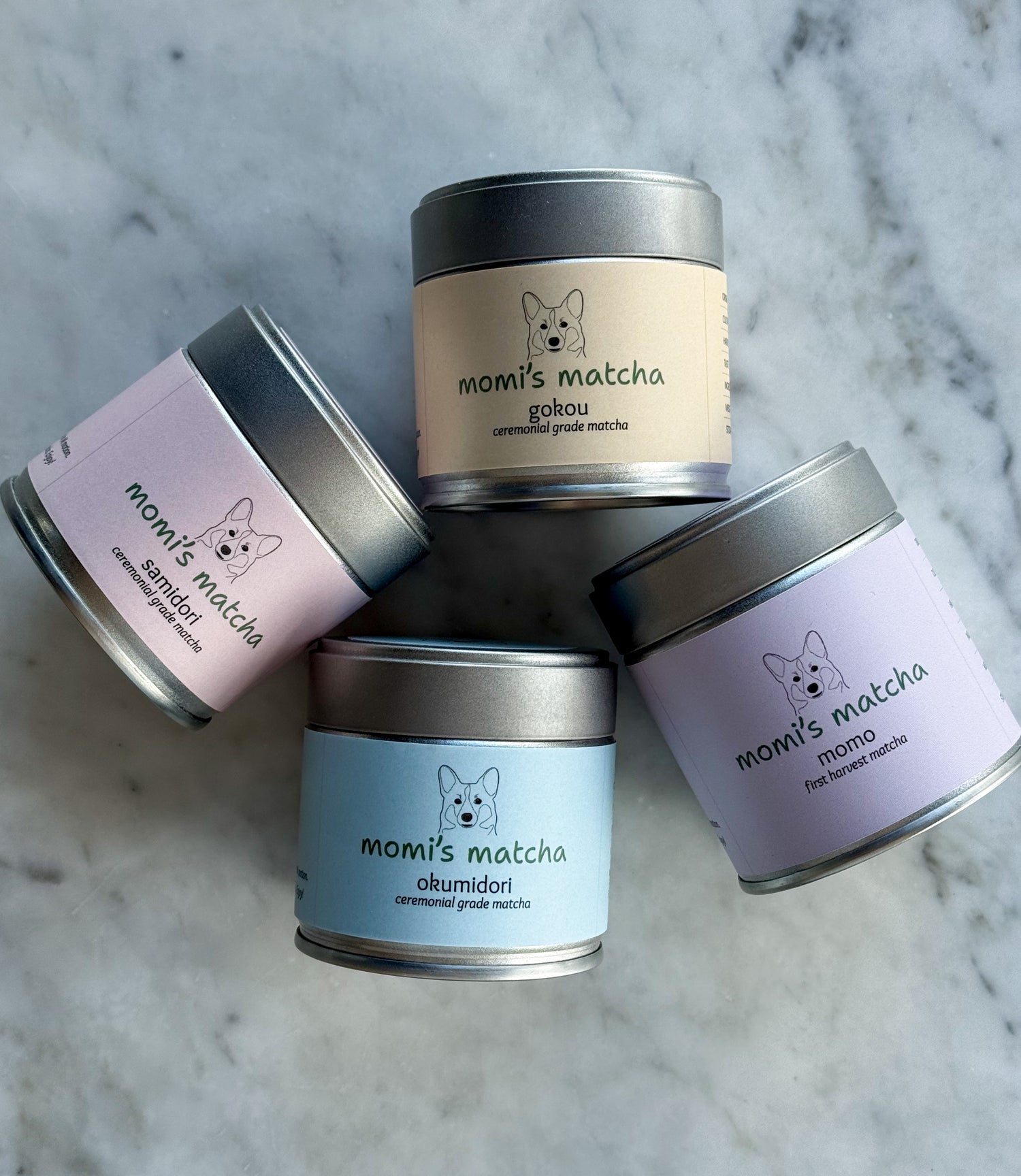 Four tins of 'momiji matcha' on a marble surface